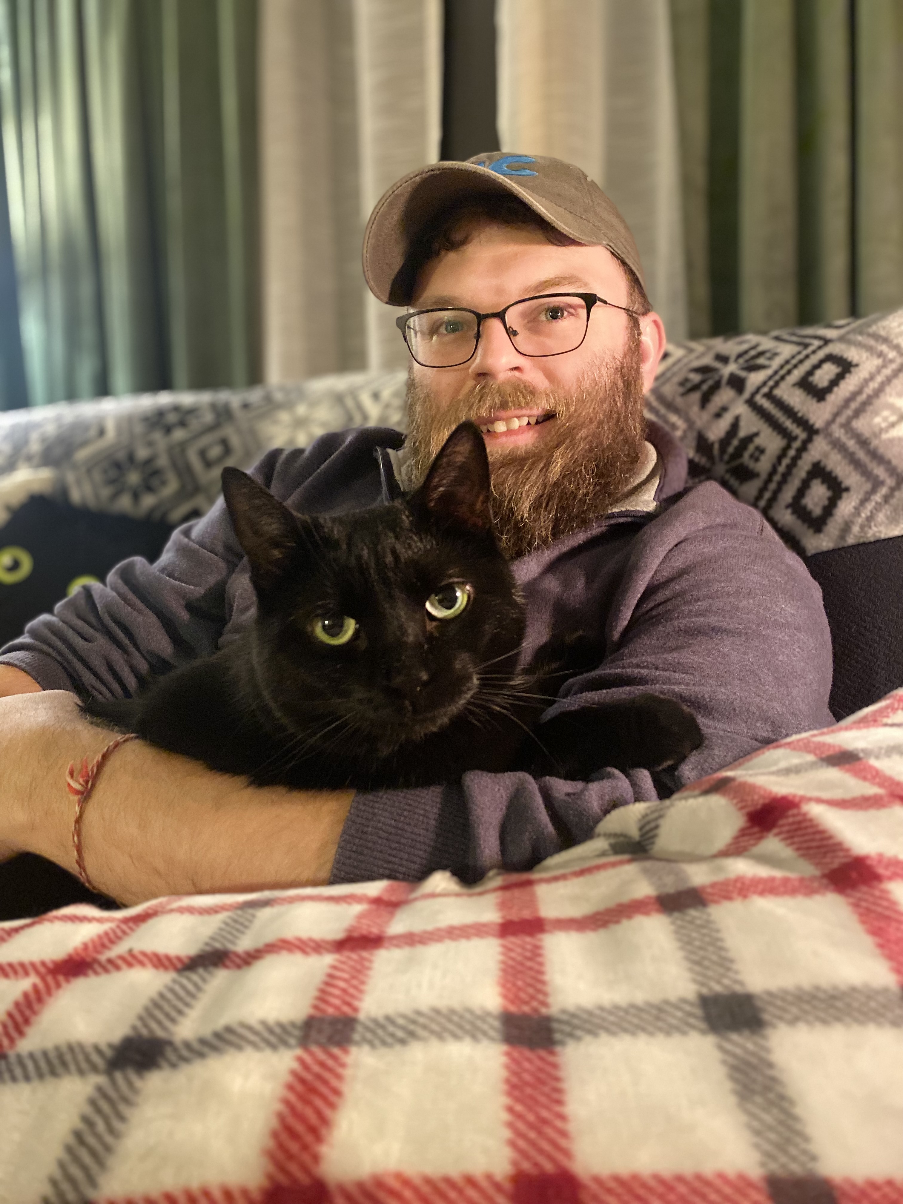 Ben holding a black cat named Maisie 